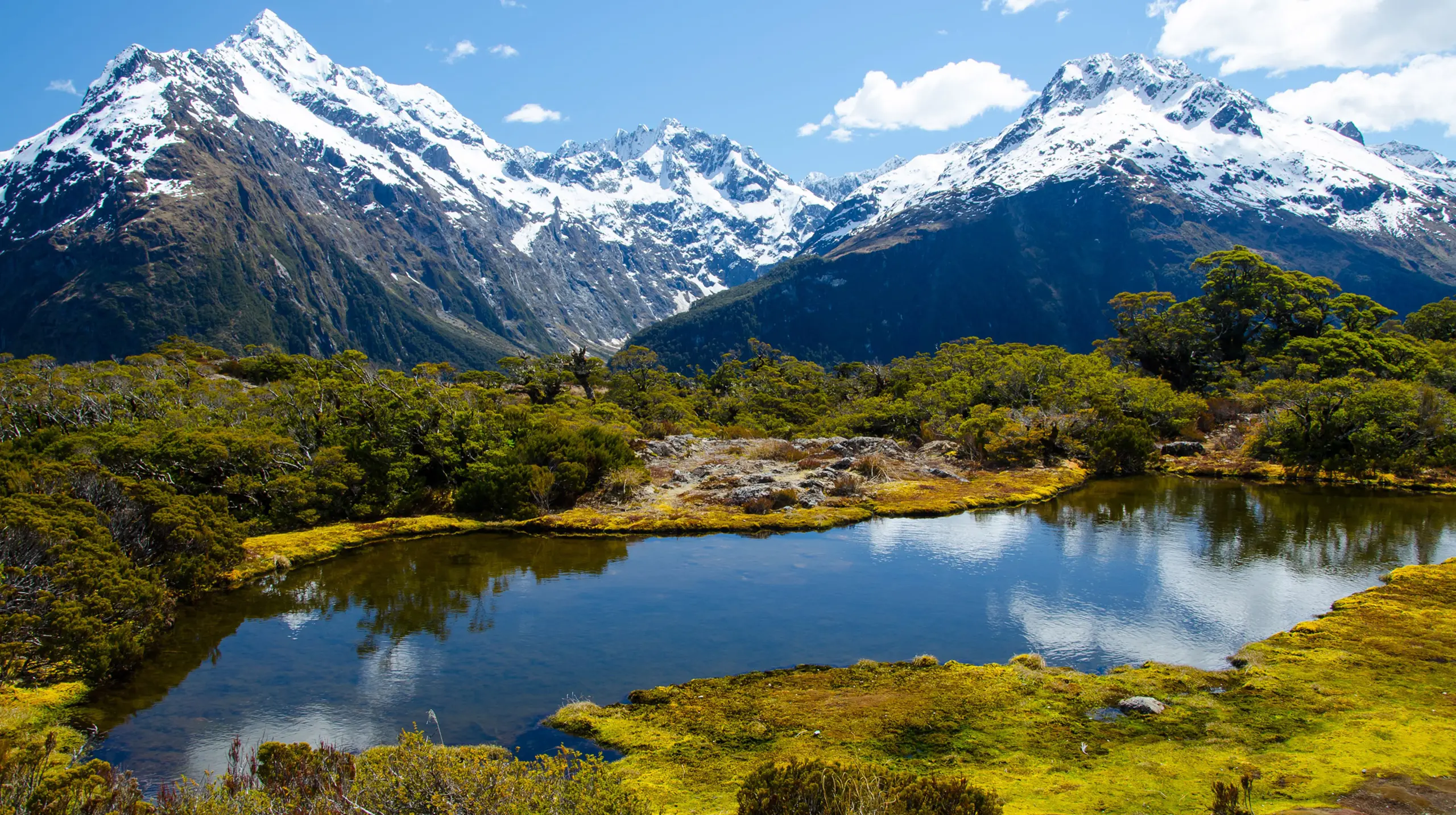 Vista del lago Marian in Nuova Zelanda, circondato da montagne innevate e vegetazione rigogliosa, viaggi personalizzati Monica Alberghini.