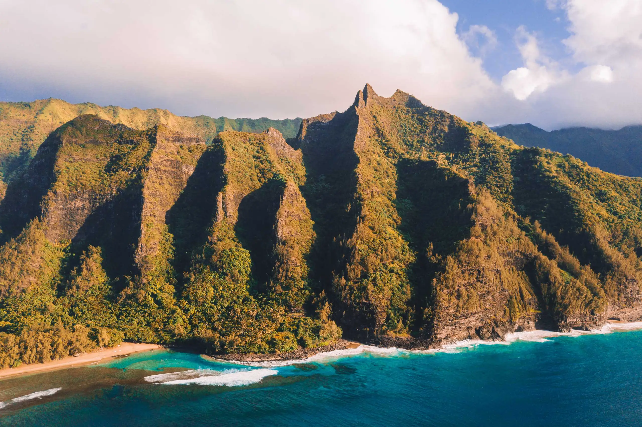 Vista panoramica della spettacolare costa montuosa delle Hawai con mare cristallino e spiaggia, Monica Alberghini viaggi su misura.