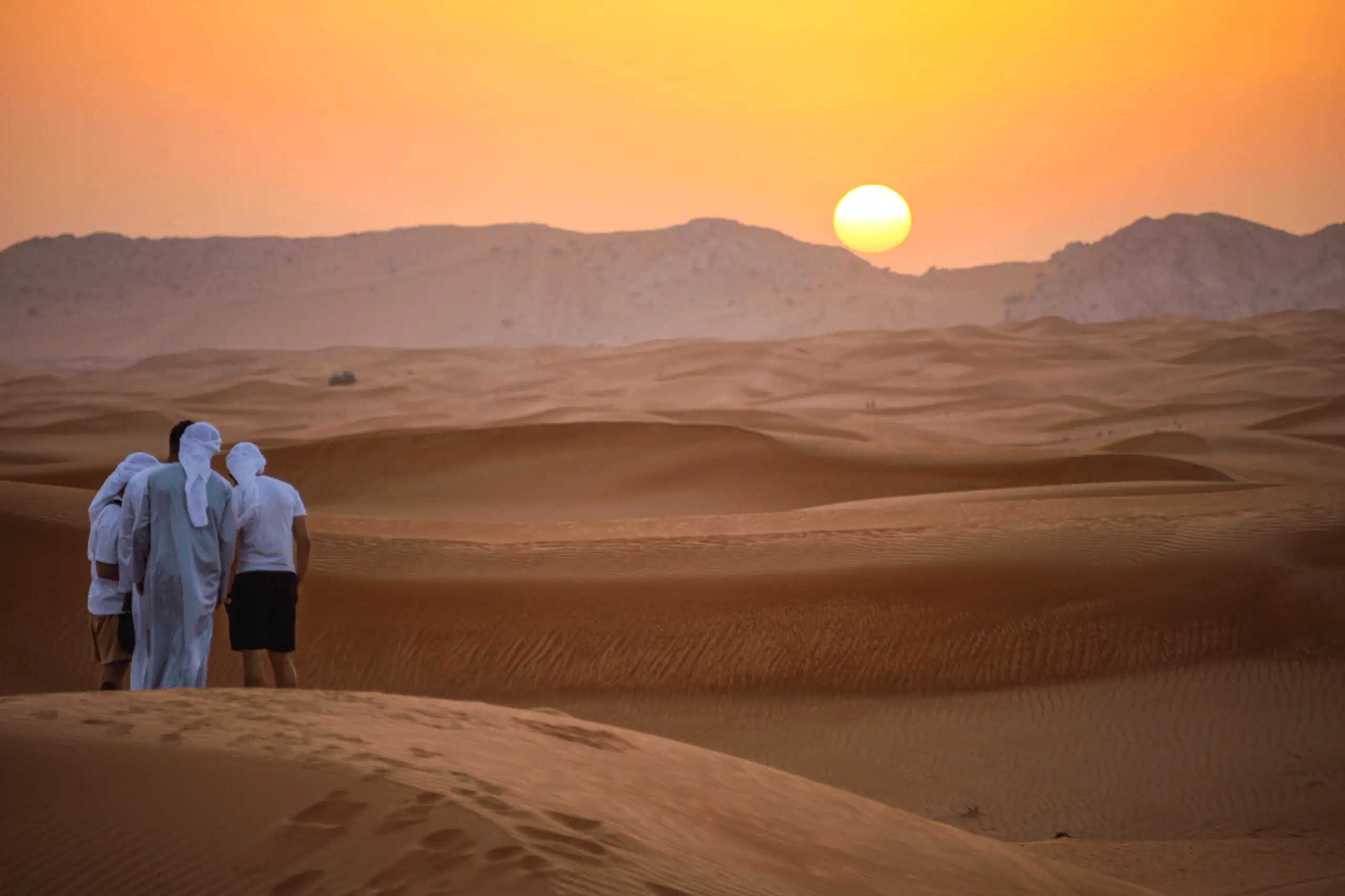 Deserto al tramonto, con un sole infuocato che illumina il paesaggio, idea vacanze marzo in Oman Monica Alberghini viaggi di lusso.